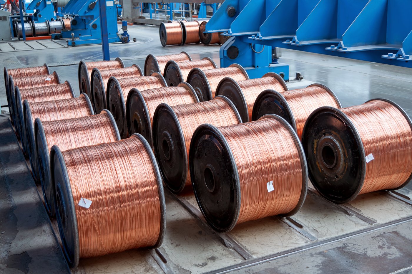 Rows of finished copper wire coils on drums in a production shop